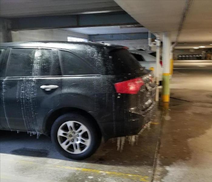 Icicles hanging from vehicle in a parking garage.  